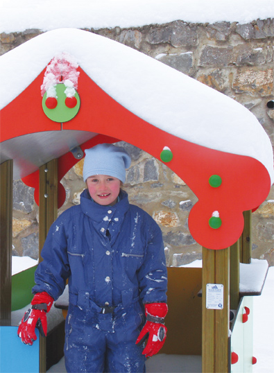 girl in a snow-covered wooden playhouse