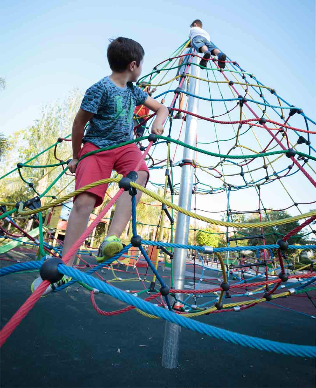 boys playing in a climbing pyramid in children's playgrounds