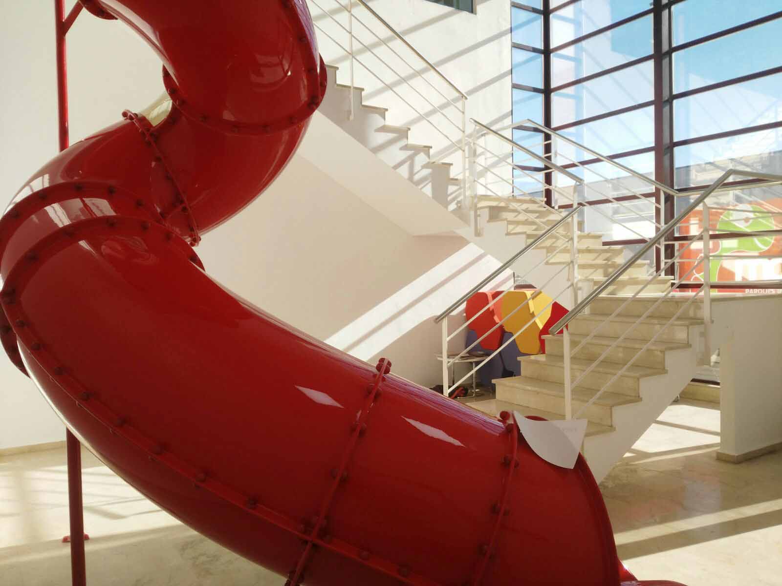 red helical slide inside of a building