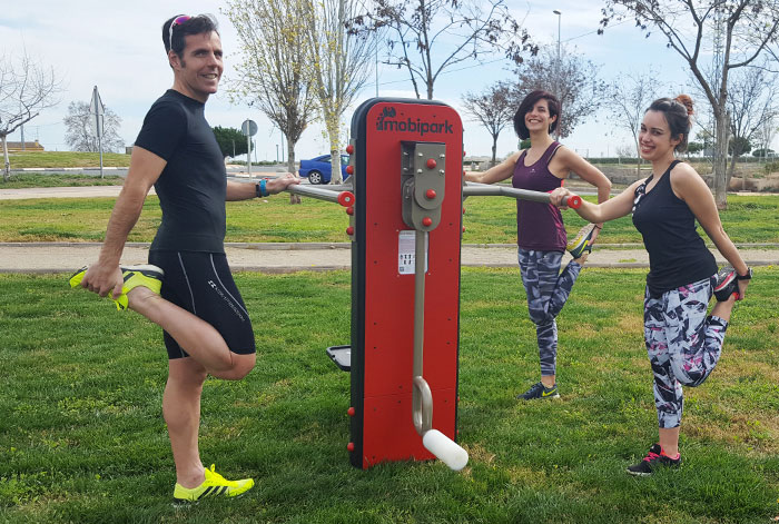 Étirements ou stretching pour groupes de personnes avec les éléments de fitness dans un parc urbain.